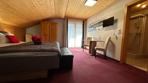 a bedroom with a bed and a desk and a television at Pension Pichlerhof in Stall