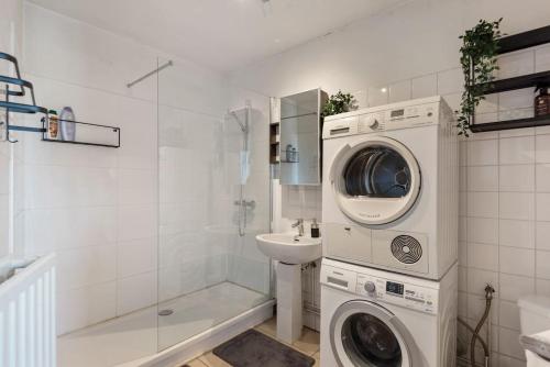 a bathroom with a washing machine and a sink at Cozy Antwerp - Zurenborg Skyline in Antwerp