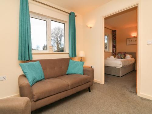 a living room with a couch and a bed at Larchwood Lodge in Ilfracombe