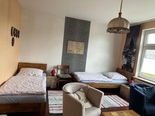 1 dormitorio con 2 camas individuales y 1 silla en Ferienwohnung Kuderer en Lunden