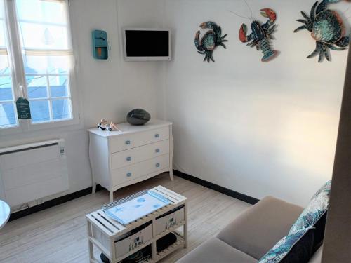 Habitación con cama, tocador y TV. en LE PETIT CABOURG de LA COUR NORMANDE Studio coeur de ville -1 à 2 personness, en Cabourg