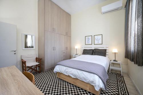 a bedroom with a large white bed and a chair at Casa Vecchia 1930’s Central Masterpiece in Kos