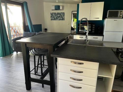 a kitchen with a sink and a counter top at bungalow vue mer au Village de l’Eperon in LʼÉperon