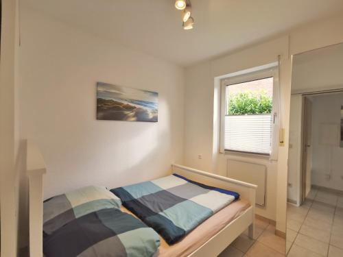 1 dormitorio con cama y ventana en Strandnah en Horumersiel