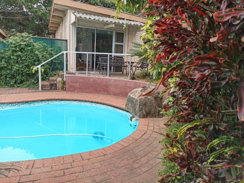a swimming pool in front of a house at Whispering Waves in Bazley Beach
