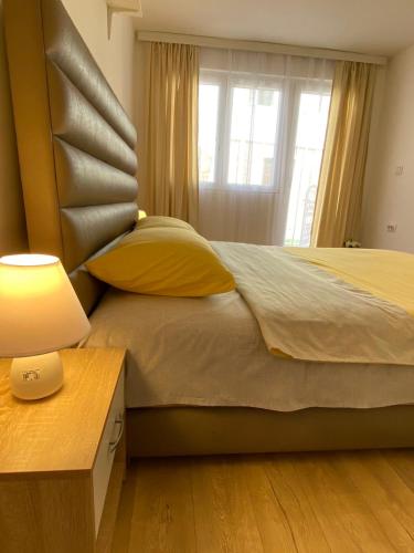 a bedroom with a bed with a lamp and a window at Apartman MiNa in Mataruška Banja