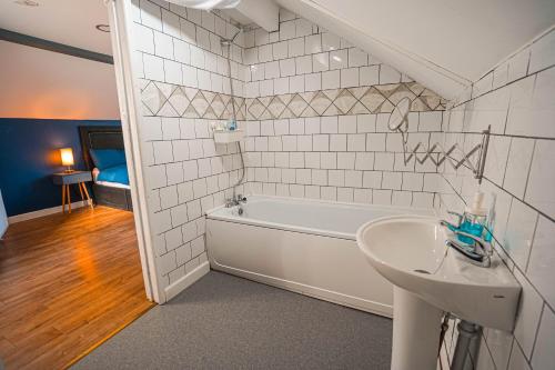 a bathroom with a bath tub and a sink at Private and Spacious 2 Bedroom House - Free Parking! in Cardiff