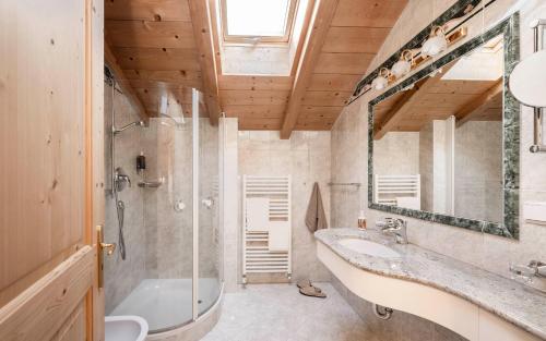 Un baño con bañera, lavabo y espejo. en Radhof, en Villandro