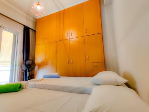 1 dormitorio con 2 camas y armarios de color naranja en Spacious 2bedroom apartment near Athens and sea, en Atenas