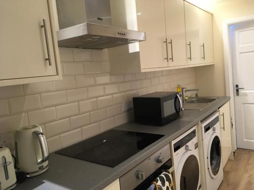een keuken met een wastafel en een magnetron bij Private One Bedroom Apartment in Slades Green