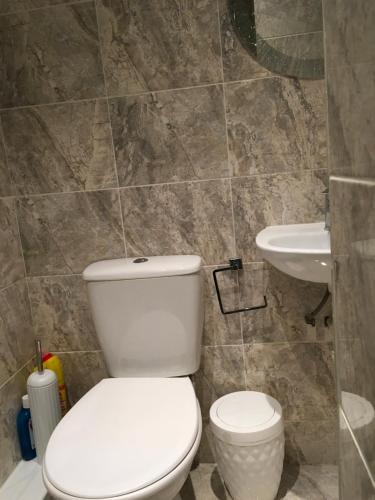 La salle de bains est pourvue de toilettes blanches et d'un lavabo. dans l'établissement Private One Bedroom Apartment, à Slades Green