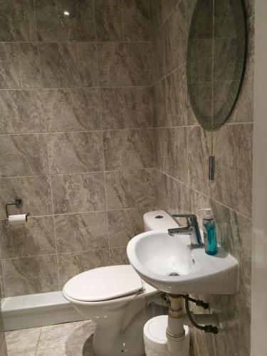 y baño con lavabo, aseo y espejo. en Private One Bedroom Apartment en Slades Green