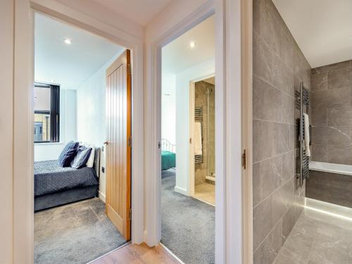 a bathroom with a walk in shower next to a bedroom at Queens Bridge Apartment in Ramsgate