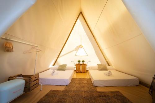 a room with two beds in a tent at Kampaoh Valdevaqueros in Tarifa