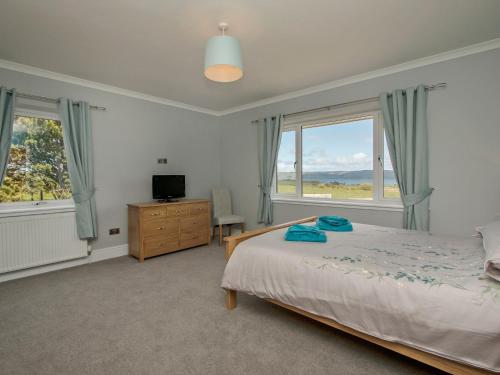 a bedroom with a bed and a large window at Quarter Acre House in Challoch