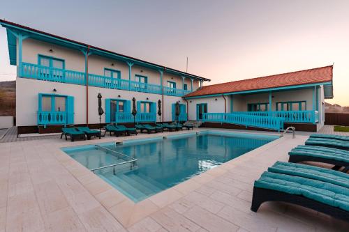 un hotel con piscina frente a un edificio en Vila Mavis-cazare cu piscina incalzita 1 mai-30 sept, en Mahmudia