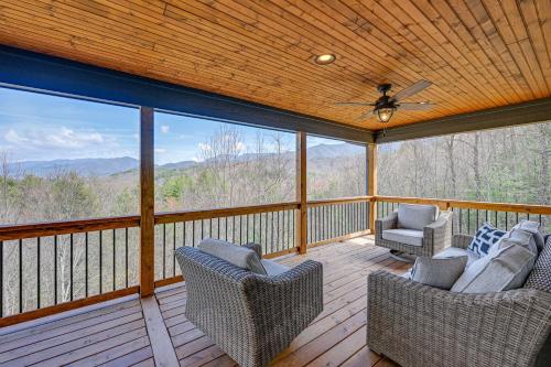 a screened in porch with two chairs and a ceiling fan at Smoky Mountain Cabin Rental Game Room, Fire Pit! in Andrews