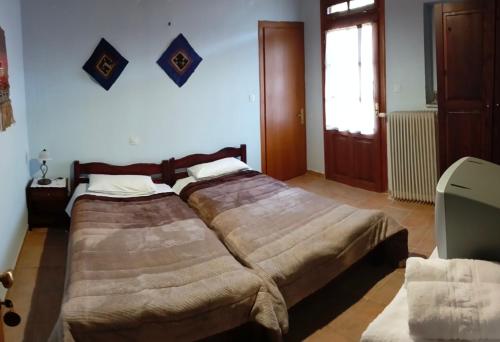 a bedroom with two beds and a window at Varnous Hotel in Agios Germanos
