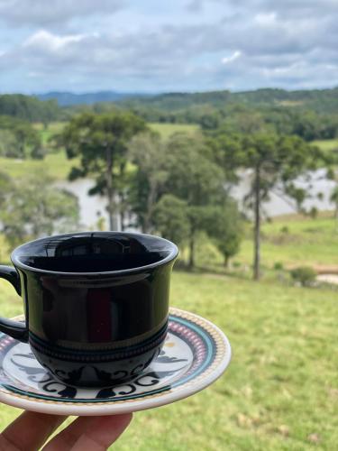 a black coffee cup sitting on top of a plate at Cabanas Serra Grande - Boa Vista in Gramado