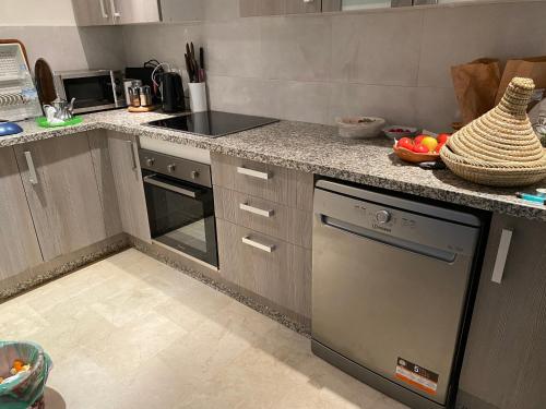 a kitchen with a counter top with a dishwasher at Apartement Marina Zina, Agadir in Agadir