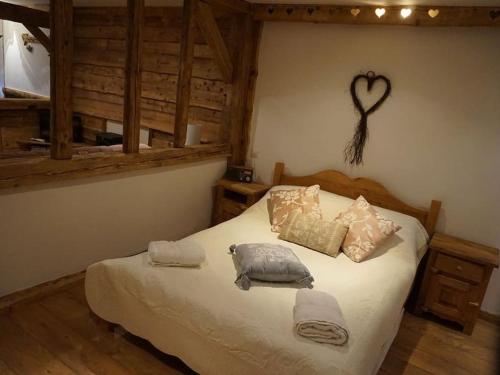 a bedroom with a bed with pillows and a heart on the wall at La Grange de Pimberty - Beautiful apartments 27 miles from Geneva in Vailly