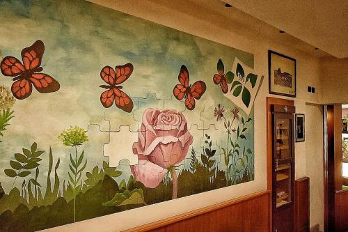 a wall with a painting of butterflies and a flower at Sale Hotel in Posada