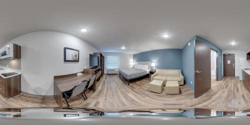 sala de estar con cama y escritorio en una habitación en WoodSpring Suites South Brunswick - Princeton, en Monmouth Junction