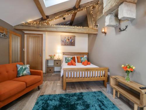 a bedroom with a bed and a couch and a table at Bess Cottage in Hebden Bridge
