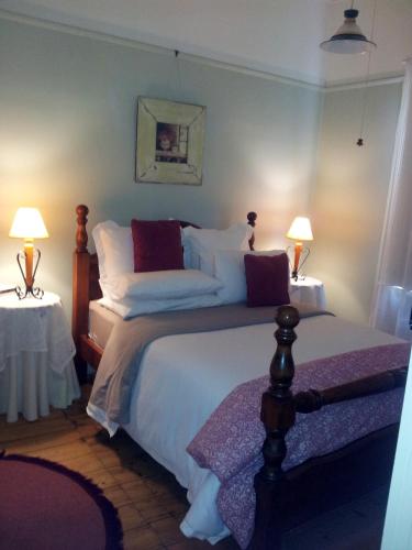 a bedroom with a bed with two tables and two lamps at Leafield Cottages in Dixons Creek