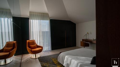 Habitación de hotel con 1 cama y 2 sillas en Quinta das Donas, en Anadia