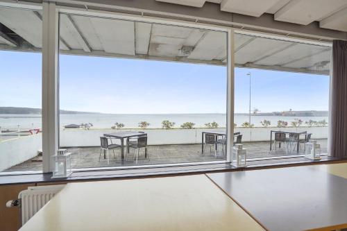 a large room with tables and chairs and a large window at Hotel Østersø in Aabenraa