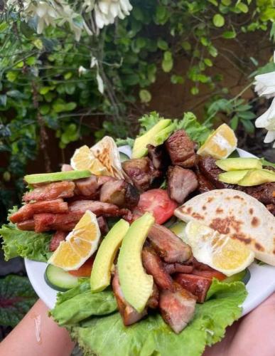 a plate of food with meat and fruits and vegetables at Tour zona arqueológica Ek Balam, cenote y pueblo mágico in Temozón