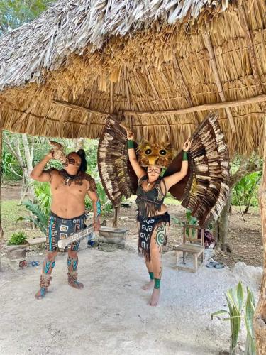 two men are standing under a thatched hut at Tour zona arqueológica Ek Balam, cenote y pueblo mágico in Temozón