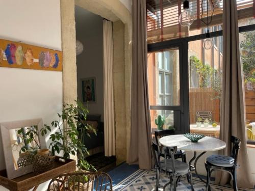 une pièce avec une table, des chaises et une fenêtre dans l'établissement un oasis au coeur de la vieille ville, classé 4 étoiles, à Montpellier
