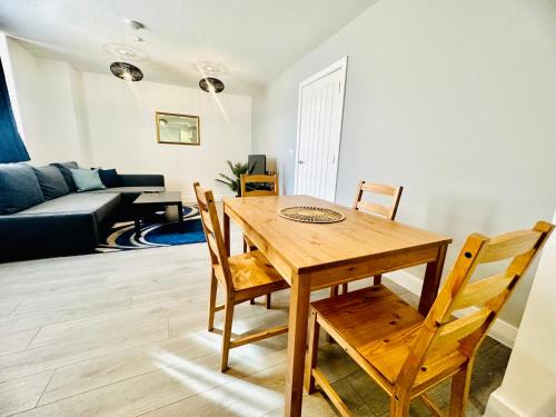a dining room with a wooden table and chairs at Hemel Apartments - Sea Breeze in Hemel Hempstead