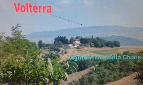 a house on a hill in the middle of a field at Agriturismo Santa Chiara in Pomarance