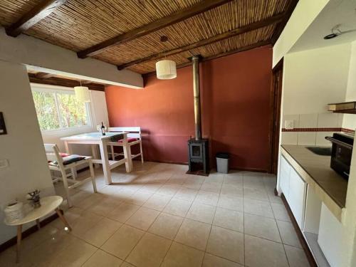 a kitchen with a table and a stove in a room at Cabaña Chacras de Caro in Chacras de Coria