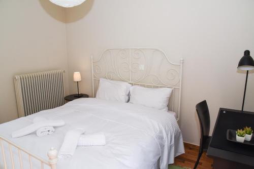 een slaapkamer met een wit bed met witte lakens en kussens bij Sunny and Quiet 1 Bedroom Apt in Athene