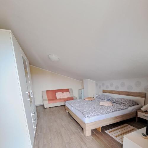a small bedroom with a bed and a couch at Sobe ROOMS TEA in Buje