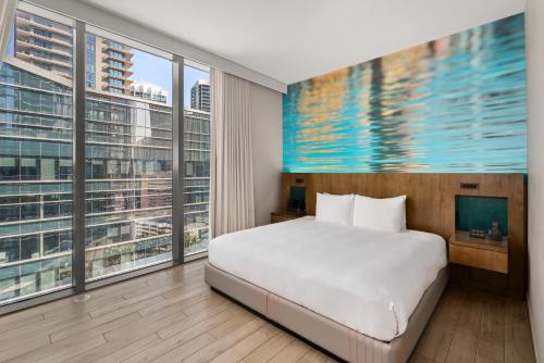 a bedroom with a bed and large windows at EAST Miami Residences in Miami