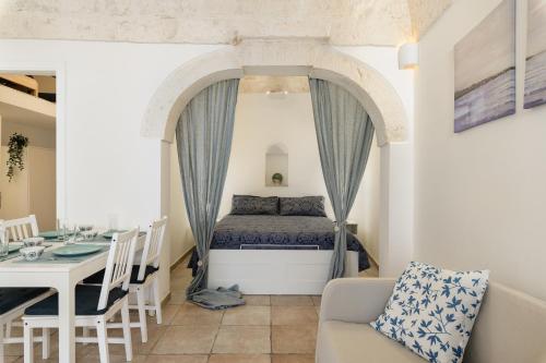 een woonkamer met een bed en een tafel bij Cozy Historic Home by Wonderful Italy in Ostuni