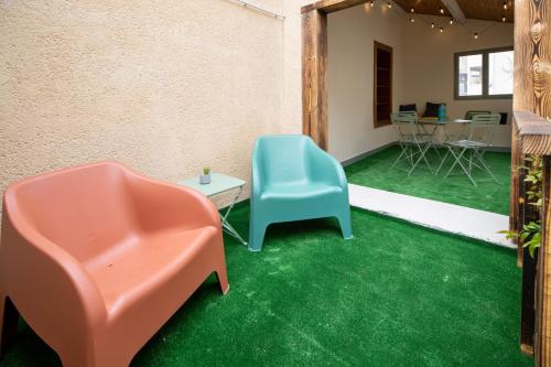 Habitación con 2 sillas y alfombra verde. en La maison de ville, en Saint-Junien