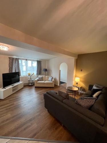 a living room with a couch and a tv at Nearby Glastonbury, Next to Street Town Centre - Ground Floor Large 3 BD With Parking, Sleeps Up to 6 in Street