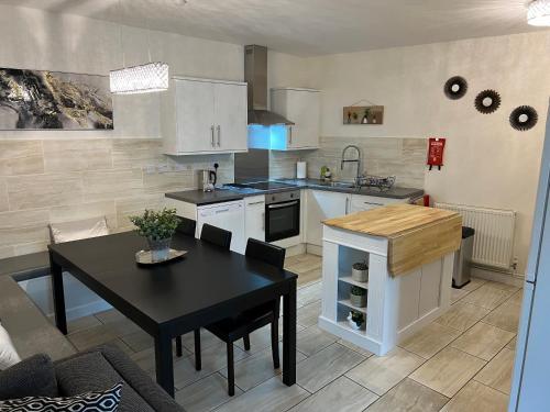 a kitchen with a black table and a black dining room at Nearby Glastonbury, Next to Street Town Centre - Ground Floor Large 3 BD With Parking, Sleeps Up to 6 in Street