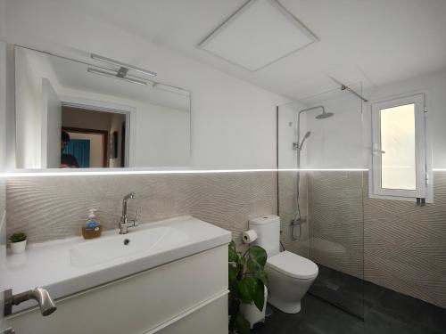 a bathroom with a sink and a toilet and a mirror at Acogedor Apartamento Residencial in Costa Teguise