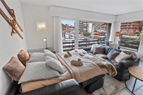 a bedroom with a large bed and a couch at Joli appartement en plein centre in Nendaz