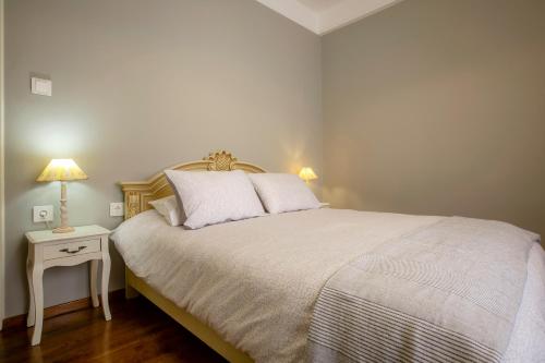 a bedroom with a bed and a table with a lamp at Le Boulevard in Corfu