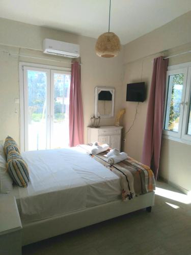 a bedroom with a large bed and a window at IOKASTI STUDIOS 5 in Andros
