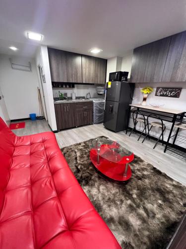een woonkamer met een rode bank en een tafel bij Hermoso apartaestudio con parqueadero in Bogota