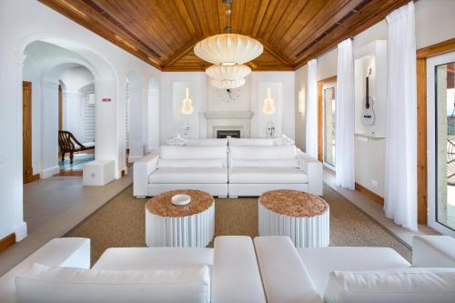 a living room with white furniture and a chandelier at Shantivillas Malhão in Azinhal